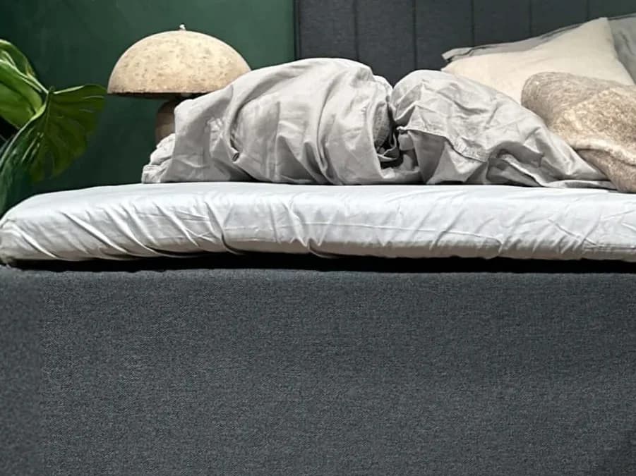 Zbliżenie prześcieradła FamBed naciągniętego na nakładkę na materac szerokiego łóżka rodzinnego