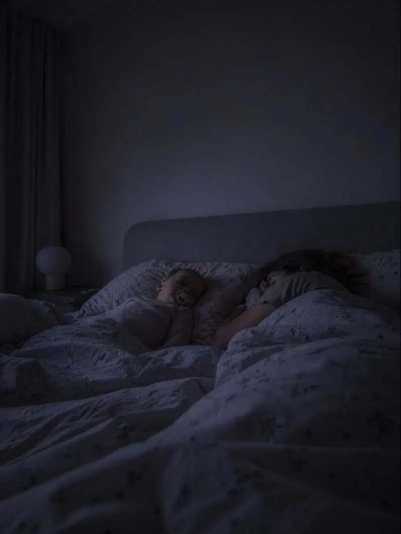 Rodzice i dziecko śpią blisko siebie w łóżku przy przygaszonym nocnym świetle